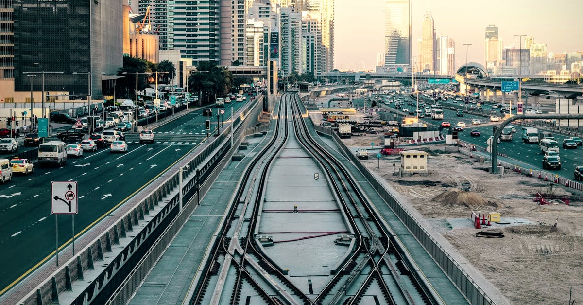 27 hours layover in Dubai and no valid visa - Tilt-shift Photography of Railway in Between of Roads at Day 27 hours layover in Dubai and no valid visa - Tilt-shift Photography of Railway in Between of Roads at Day