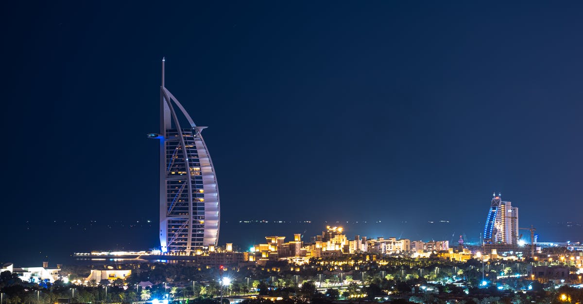 3-star hotels in Dubai, UAE [closed] - Dark blue cloudless sky above tall Burj Al Arab skyscraper hotel surrounded by buildings glowing in dark