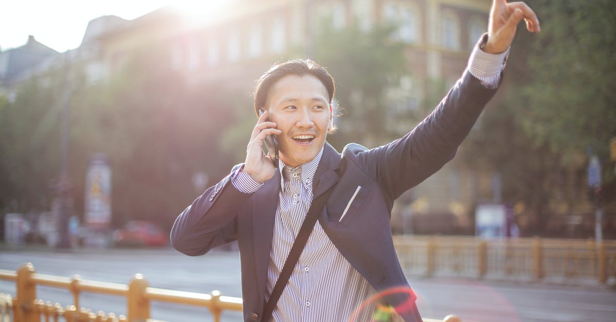4 people in a cab in London? Is that allowed? - Happy adult ethnic man in jacket waving with hand hailing taxi on sunny street while speaking on smartphone 4 people in a cab in London? Is that allowed? - Happy adult ethnic man in jacket waving with hand hailing taxi on sunny street while speaking on smartphone