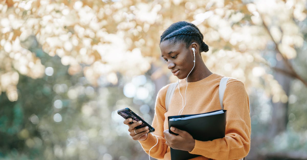 50-minute connection in Helsinki between Schengen and non-Schengen - enough time? - Positive young African American female student with earphones and folder using mobile phone in park 50-minute connection in Helsinki between Schengen and non-Schengen - enough time? - Positive young African American female student with earphones and folder using mobile phone in park