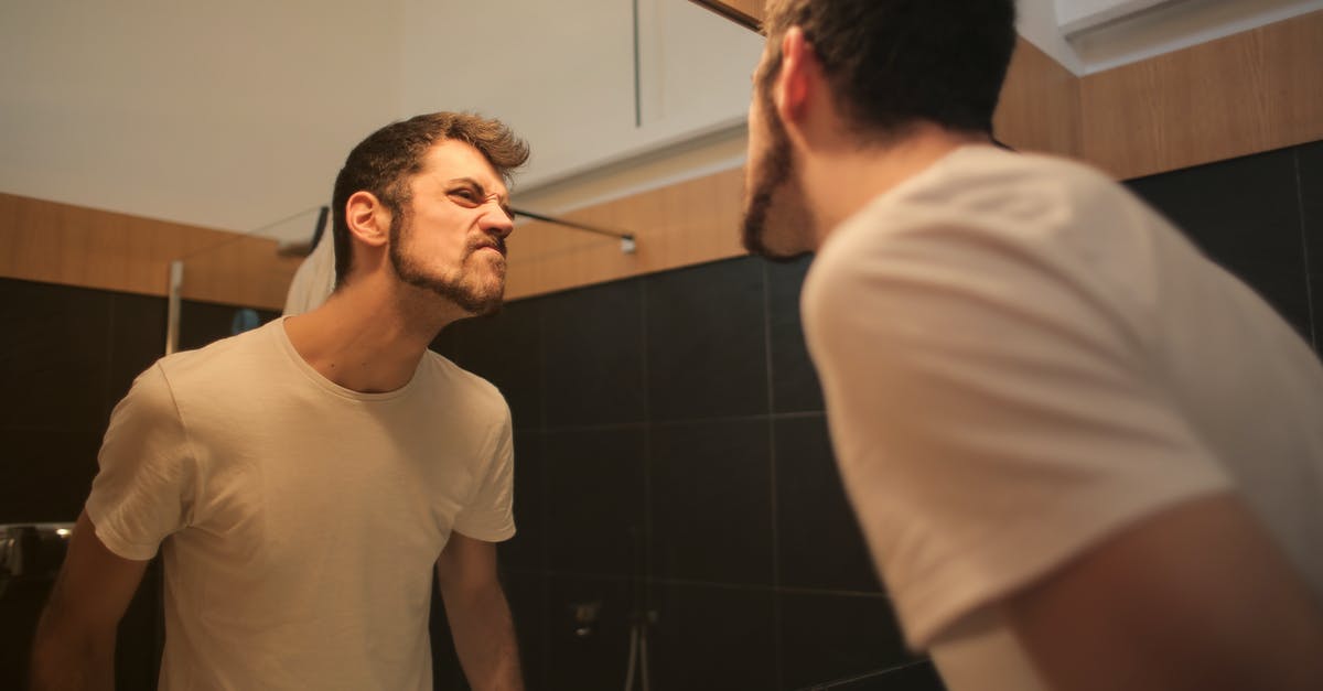 A few questions about transfering from domestic to international in Novosibirsk, Russia - Low angle side view of young bearded male in casual shirt standing in bathroom and looking at with frown mirror in morning A few questions about transfering from domestic to international in Novosibirsk, Russia - Low angle side view of young bearded male in casual shirt standing in bathroom and looking at with frown mirror in morning