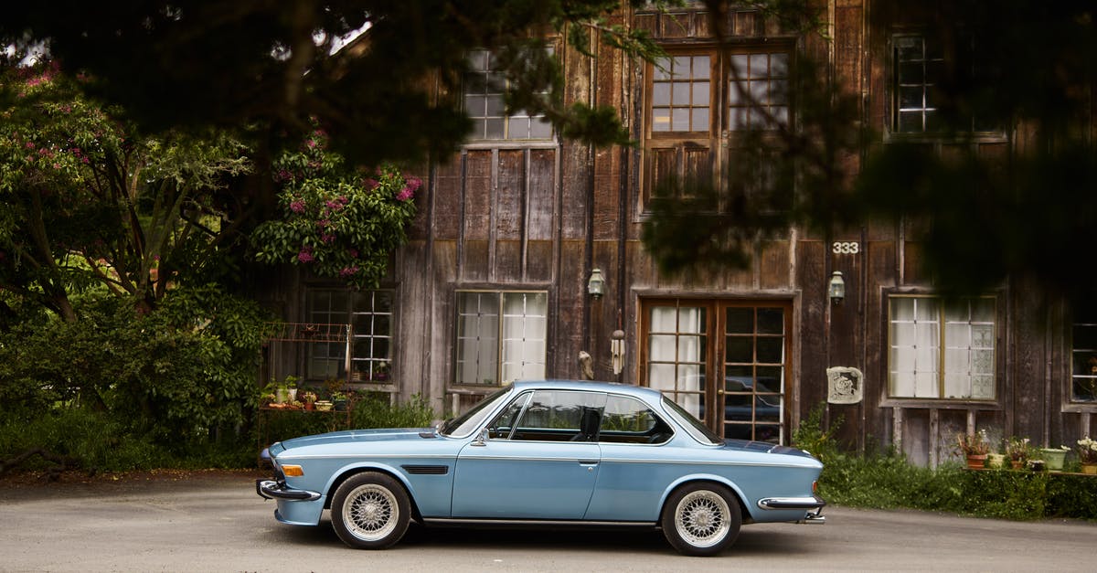 Abandon an EU registered car outside of the EU - Vintage auto parked near old house under large tree brunches Abandon an EU registered car outside of the EU - Vintage auto parked near old house under large tree brunches