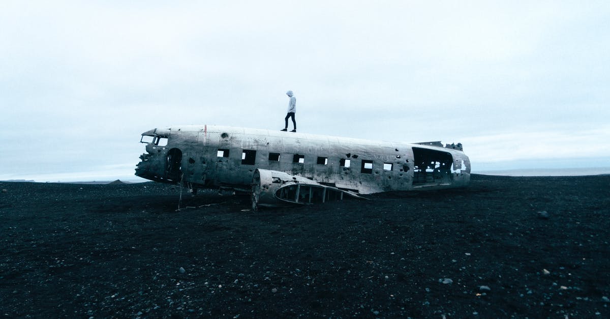 Abandoned theme parks in Iceland - Person Standing on Wrecked Plane Abandoned theme parks in Iceland - Person Standing on Wrecked Plane