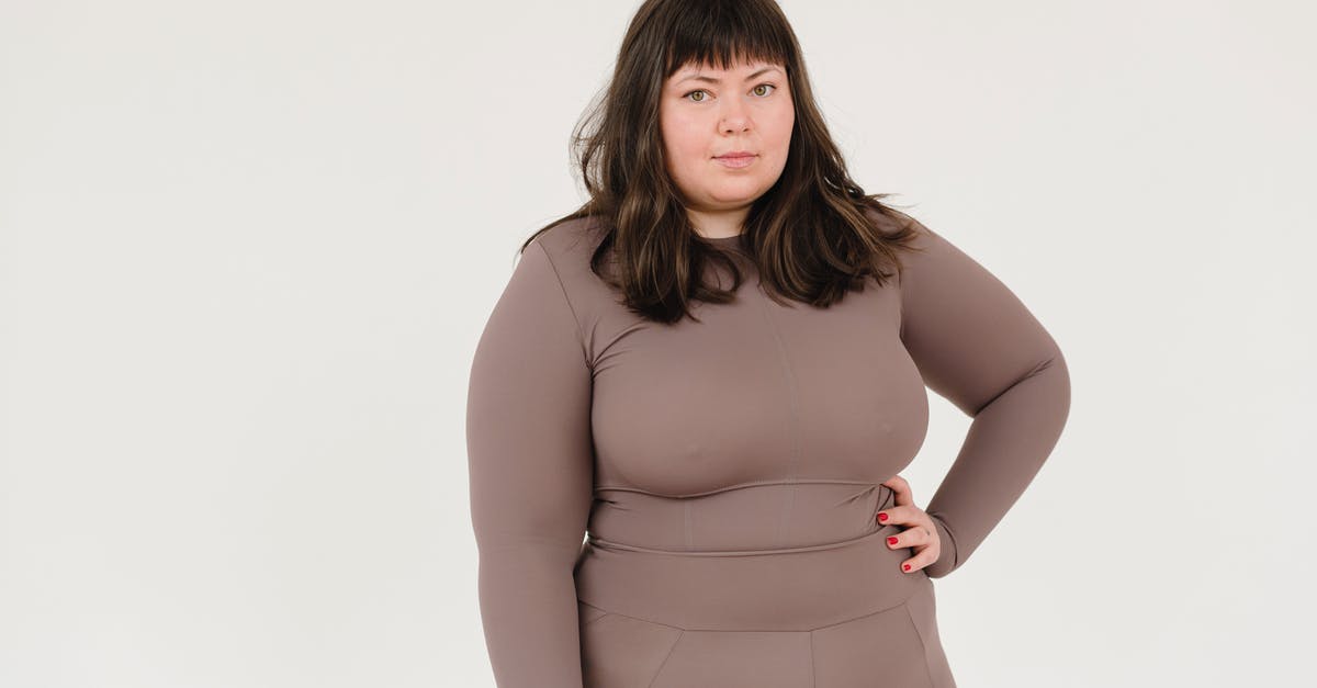 Acceptance of large bills in Denmark - Plus size female in activewear keeping hand on waist and looking at camera against white background Acceptance of large bills in Denmark - Plus size female in activewear keeping hand on waist and looking at camera against white background