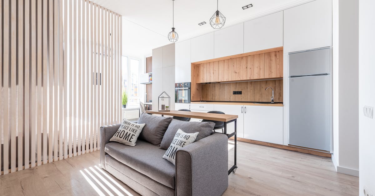 Accommodation for a large group in Cairns in November 2012 - Interior of contemporary open plan kitchen with white cabinets and cozy sofa with cushions in sunlight Accommodation for a large group in Cairns in November 2012 - Interior of contemporary open plan kitchen with white cabinets and cozy sofa with cushions in sunlight
