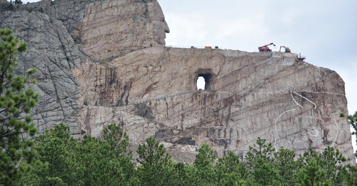 Accommodation in South America - book here or just rock up and find there? - Majestic steep Mount Rushmore surrounded by coniferous trees under light blue sky covered with clouds Accommodation in South America - book here or just rock up and find there? - Majestic steep Mount Rushmore surrounded by coniferous trees under light blue sky covered with clouds