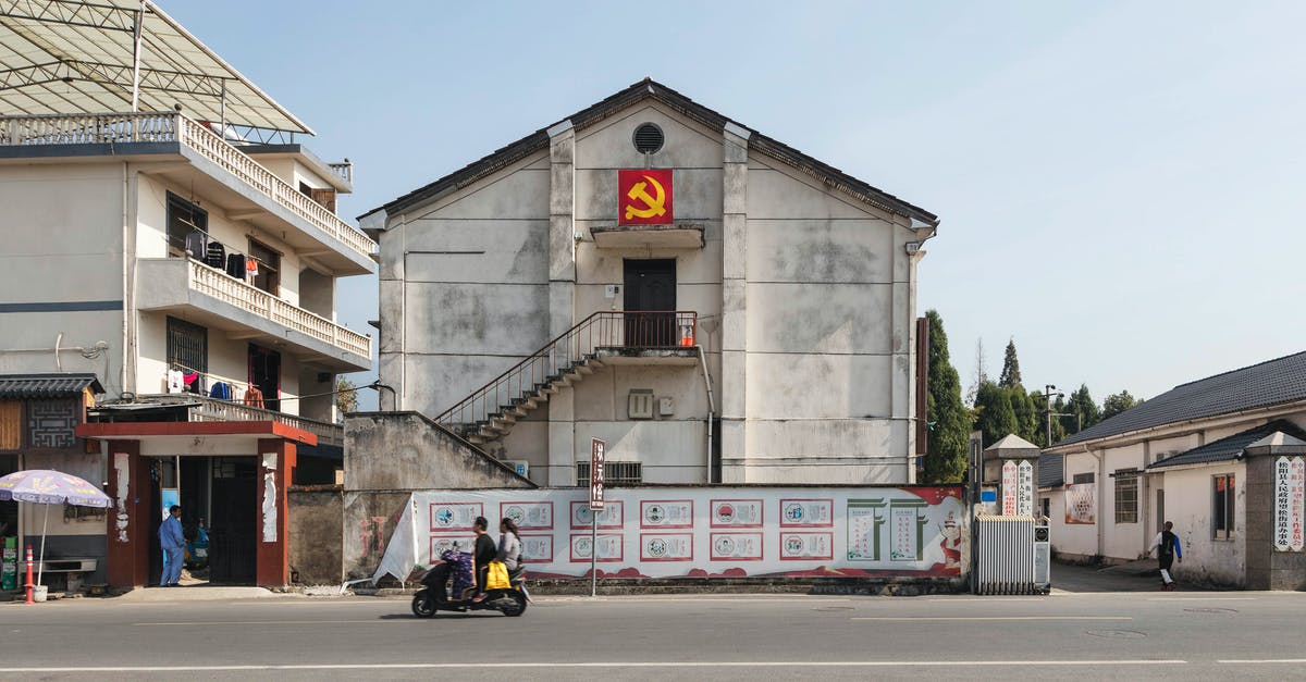 Accommodation that accepts foreigners in Dandong, China - Exteriors of low level buildings decorated with hammer and sickle flag located in suburban area in Communist country Accommodation that accepts foreigners in Dandong, China - Exteriors of low level buildings decorated with hammer and sickle flag located in suburban area in Communist country