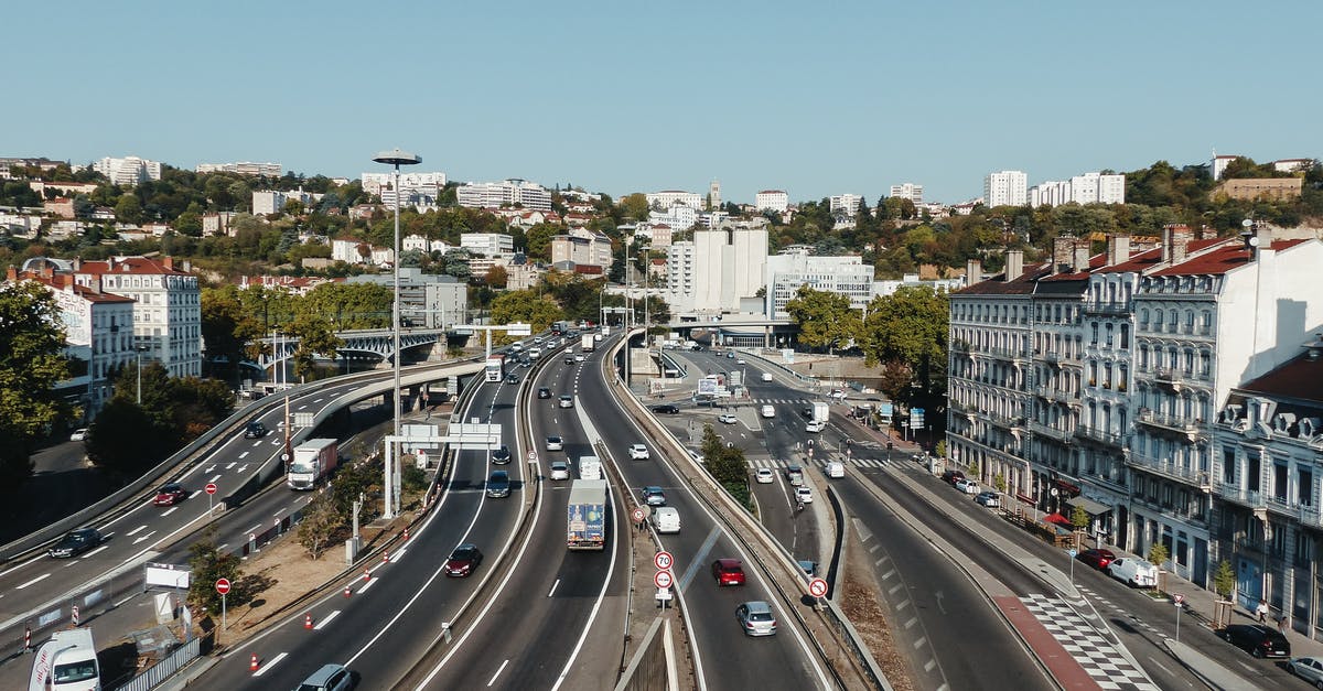 Accommodation while driving from Calais towards Paris - Highway with traffic between residential buildings in city district Accommodation while driving from Calais towards Paris - Highway with traffic between residential buildings in city district