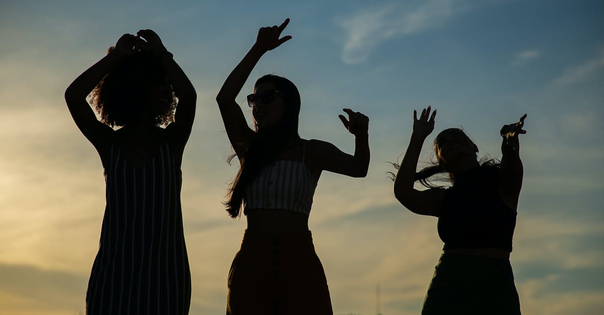 Activities in Montreal for a Bachelor party - Low angle silhouettes of unrecognizable young female friends dancing against cloudy sunset sky during open air party Activities in Montreal for a Bachelor party - Low angle silhouettes of unrecognizable young female friends dancing against cloudy sunset sky during open air party