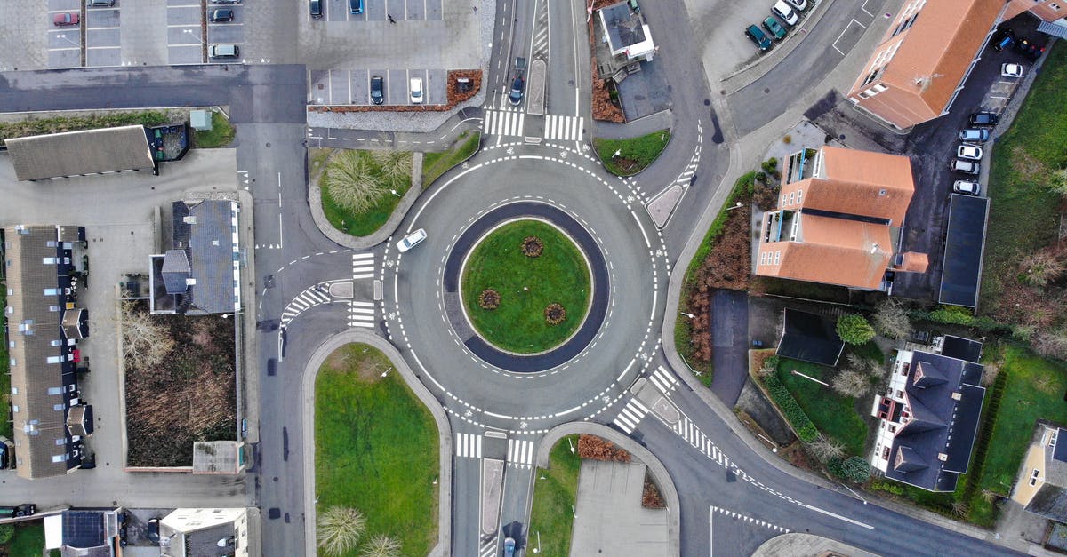 Affordable and accessible accommodation options with car parking near Paris? - Drone top view over modern roundabout road located amidst suburban houses and big parking area Affordable and accessible accommodation options with car parking near Paris? - Drone top view over modern roundabout road located amidst suburban houses and big parking area