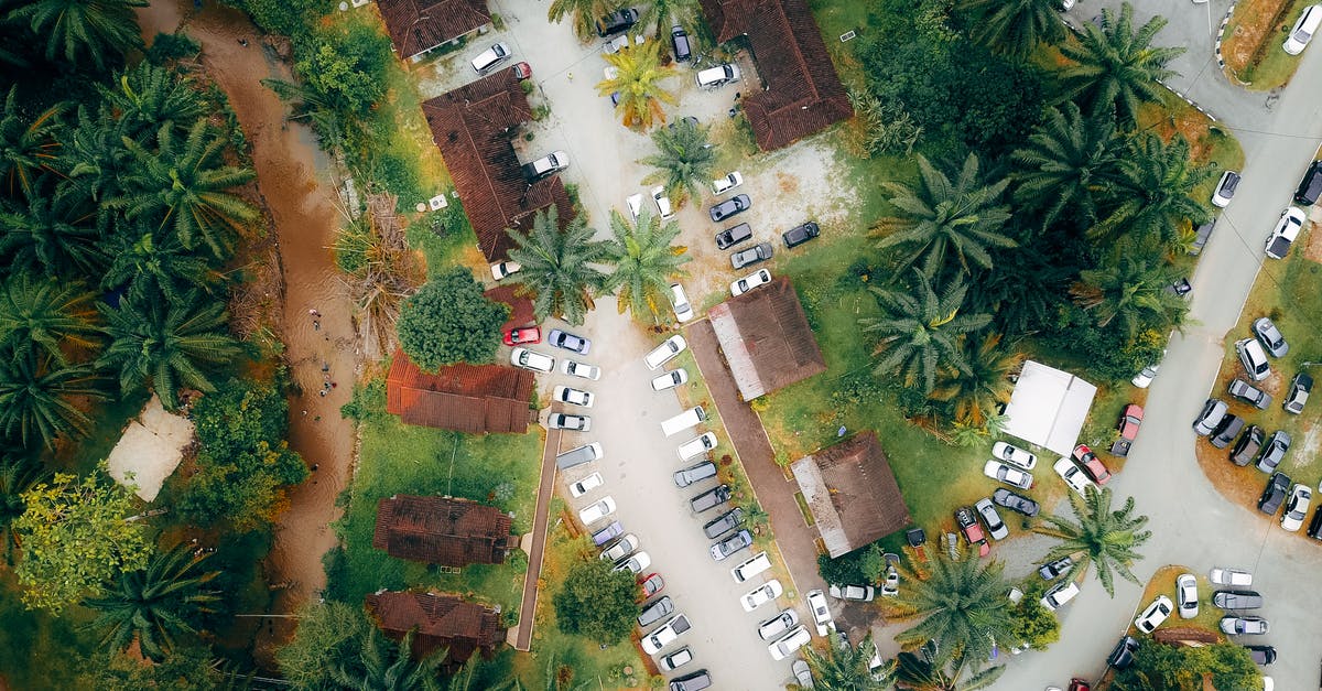 Affordable and accessible accommodation options with car parking near Paris? - Roofs of villas with parked cars in exotic resort Affordable and accessible accommodation options with car parking near Paris? - Roofs of villas with parked cars in exotic resort