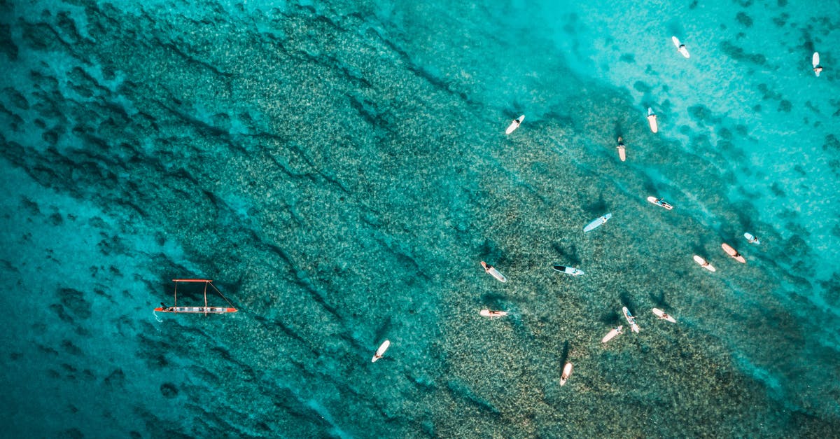 Affordable yacht holiday around Cook Islands / Pacific Islands - Picturesque aerial view of various boats floating in clear turquoise ocean with coral reefs on bottom
