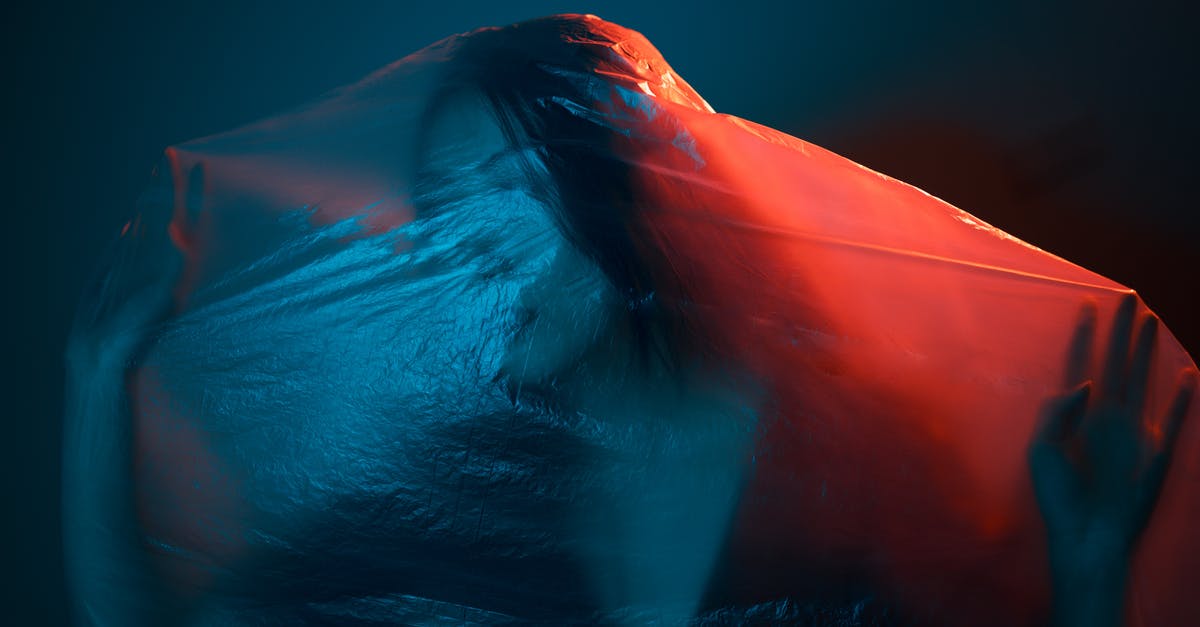 Air Canada or Delta? Which has better Bag Policy? - Unrecognizable female wrapped with translucent plastic bag in dark room with neon lights Air Canada or Delta? Which has better Bag Policy? - Unrecognizable female wrapped with translucent plastic bag in dark room with neon lights