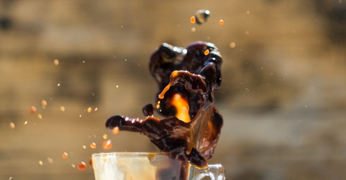 Air China/Star Alliance baggage drop at Heathrow? - Transparent glass cup with fast coffee fluid with small drips above table in house Air China/Star Alliance baggage drop at Heathrow? - Transparent glass cup with fast coffee fluid with small drips above table in house