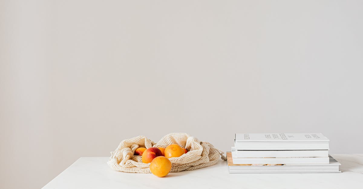 Airfare booked through third-party provider - reduced baggage and food allowance - Jute sack with natural ripe apricots on white table composed with stack of various books and magazines