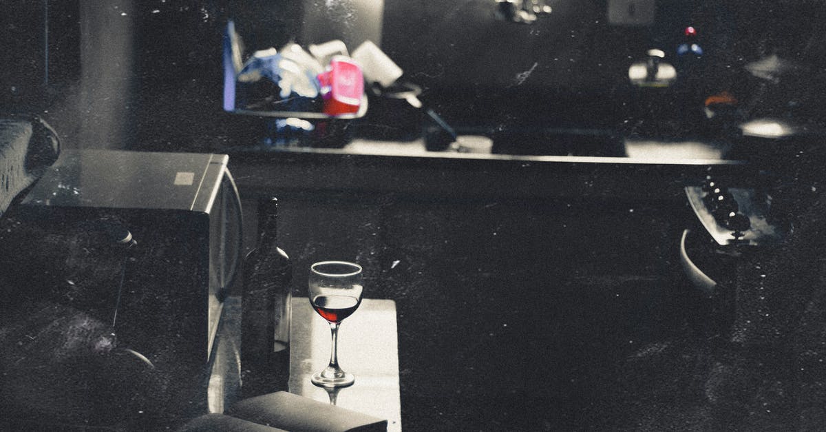 Airport security compatible container for small amounts of alcoholic spirits (drinks)? - Modern style kitchen with glass of wine and open book Airport security compatible container for small amounts of alcoholic spirits (drinks)? - Modern style kitchen with glass of wine and open book