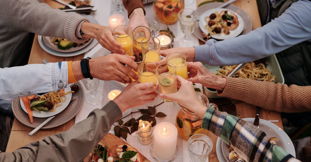 Alcohol when flying to Singapore from EU through Malaysia - From above of crop friends enjoying dinner with candles while cheering with glasses of drinks Alcohol when flying to Singapore from EU through Malaysia - From above of crop friends enjoying dinner with candles while cheering with glasses of drinks