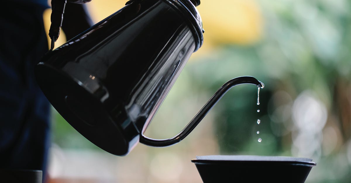 Alternative to public hot water bath in Japan for a tattooed person - Crop faceless person filling water from kettle while brewing pour over coffee Alternative to public hot water bath in Japan for a tattooed person - Crop faceless person filling water from kettle while brewing pour over coffee