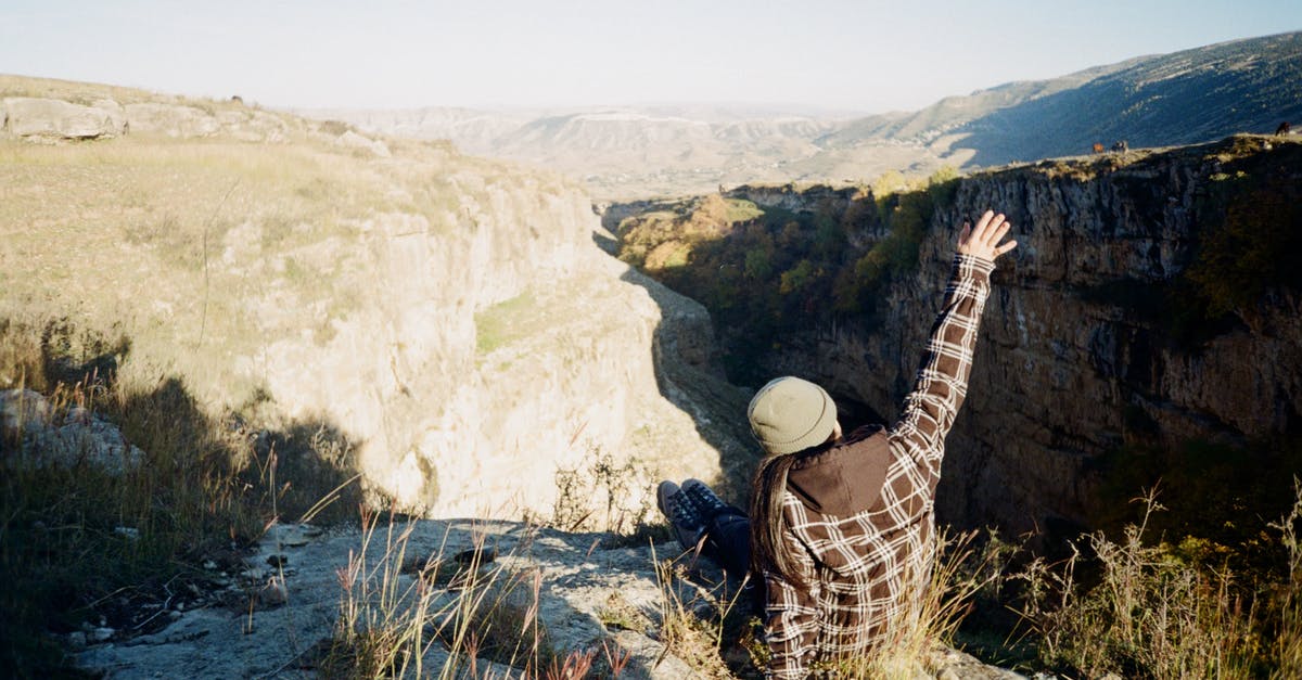 Am I a repeat traveler in terms of ESTA? - Person in Brown and White Plaid Shirt Sitting on Rocky Cliff Am I a repeat traveler in terms of ESTA? - Person in Brown and White Plaid Shirt Sitting on Rocky Cliff