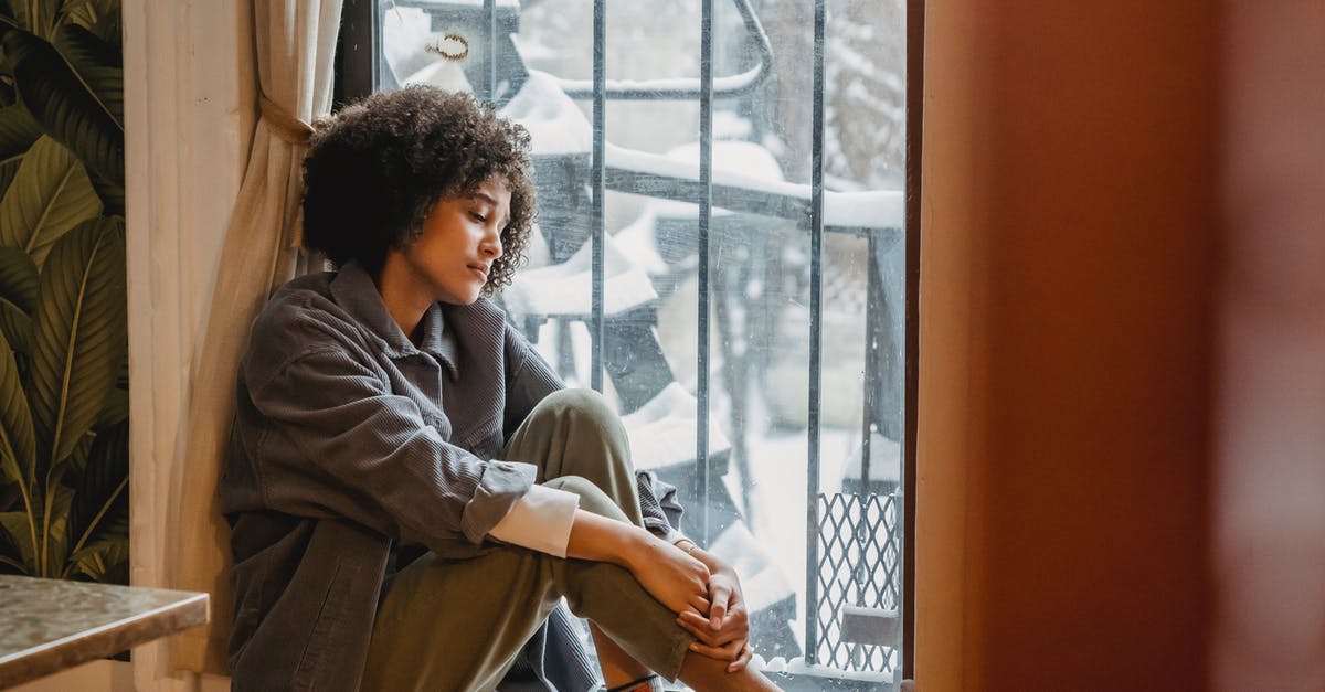 Am I going to have trouble flying without my full name on the ticket? [duplicate] - Side view full body of upset African American woman embracing knees while sitting in solitude near window and looking down