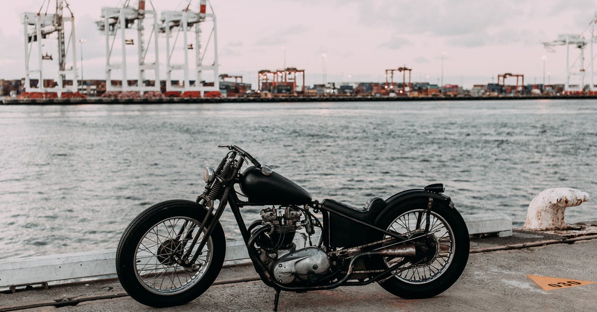 Amalfi coast by motor bike? [closed] - Vintage motorcycle on asphalt embankment near rippling river water against industrial area in city