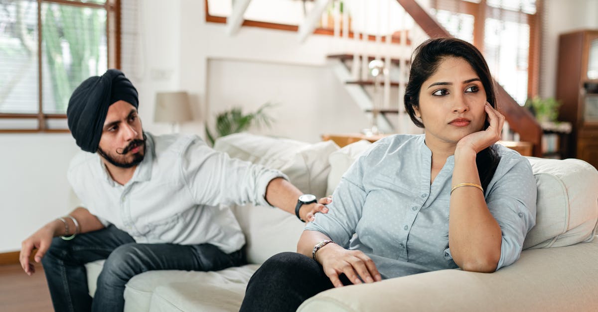 American ID requirements for indian domestic flights - Thoughtful man talking to upset woman on couch American ID requirements for indian domestic flights - Thoughtful man talking to upset woman on couch