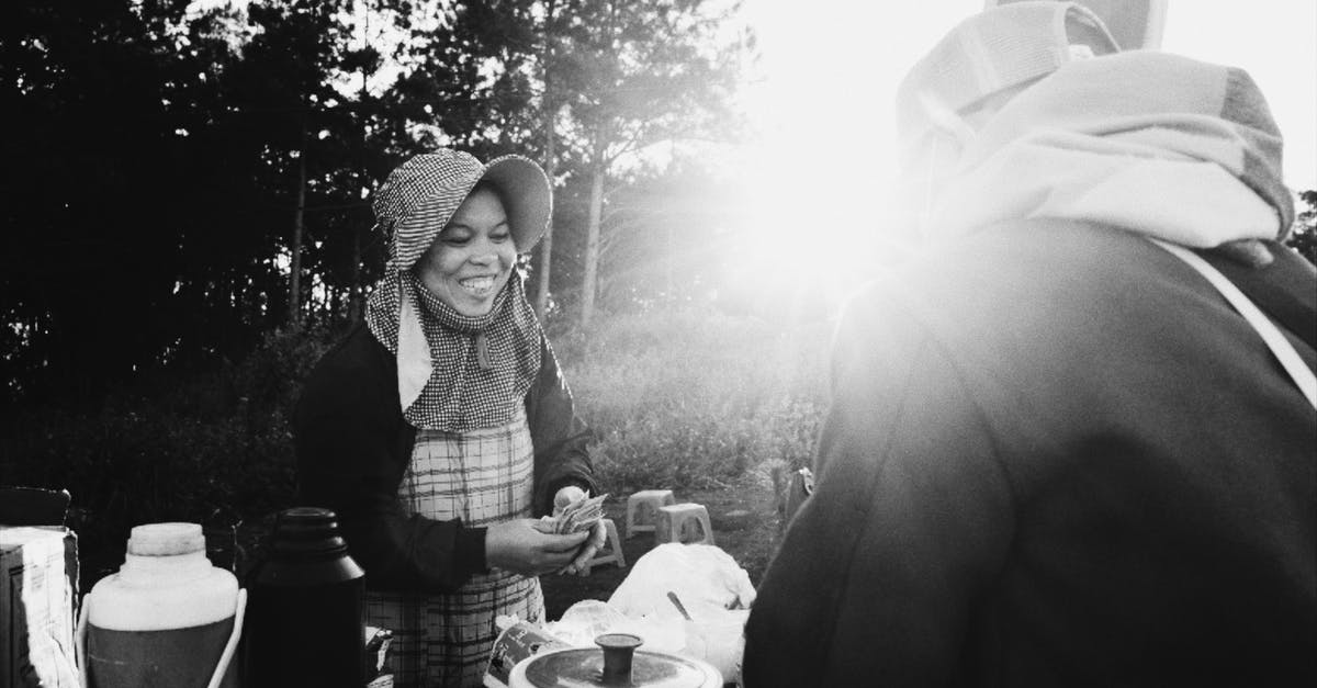 American traveling to Switzerland 5 days before work visa is valid [duplicate] - Black and white of smiling African American female wearing warm clothes standing near table and offering drink to anonymous man in sunny day