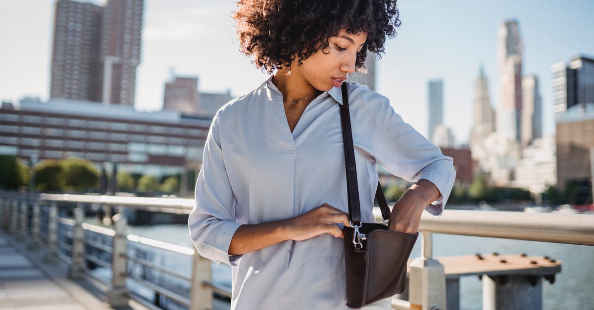 American woman getting Saudi visa in Abu Dhabi - Photo of a Woman in a Blue Shirt Finding Something in Her Bag American woman getting Saudi visa in Abu Dhabi - Photo of a Woman in a Blue Shirt Finding Something in Her Bag