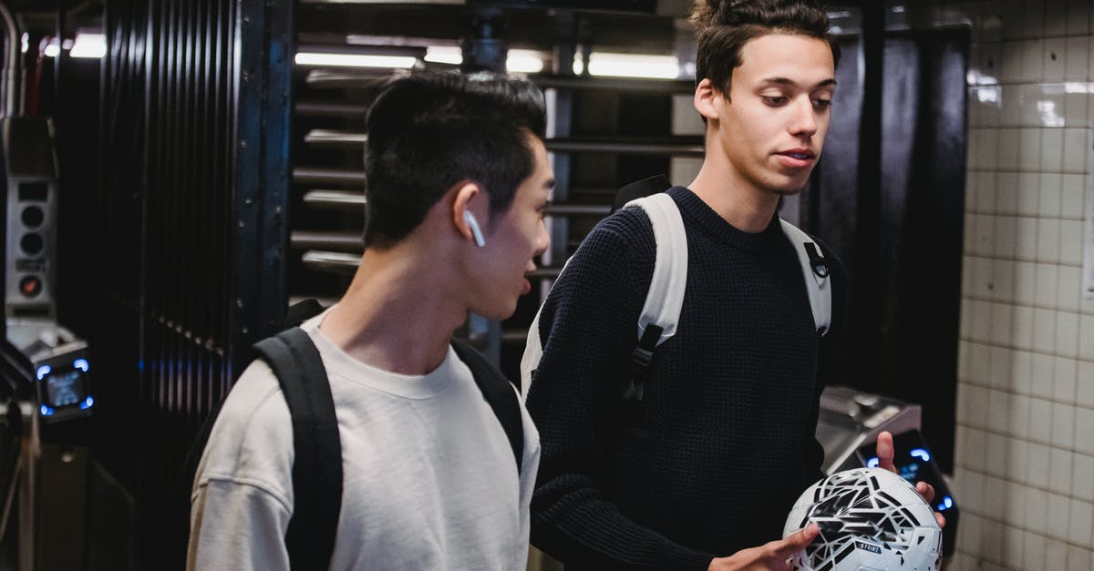 An active underground city/village? - Young men with soccer ball walking in metro station An active underground city/village? - Young men with soccer ball walking in metro station