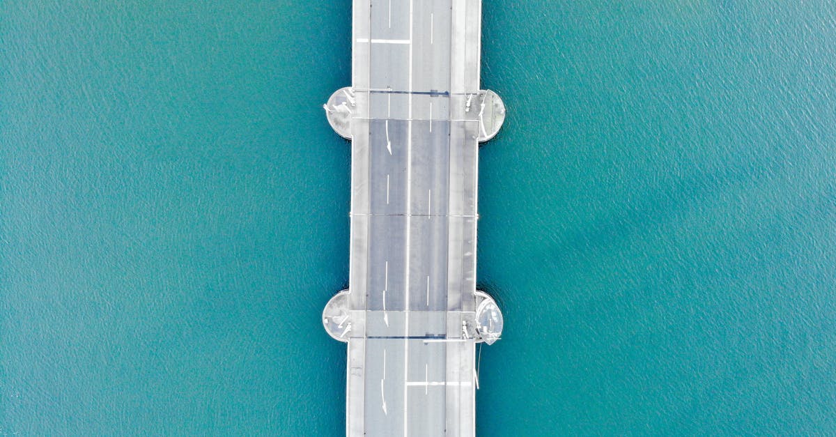Another scenic pass, near the Stelvio pass - Drone view of modern asphalt bridge over blue water Another scenic pass, near the Stelvio pass - Drone view of modern asphalt bridge over blue water