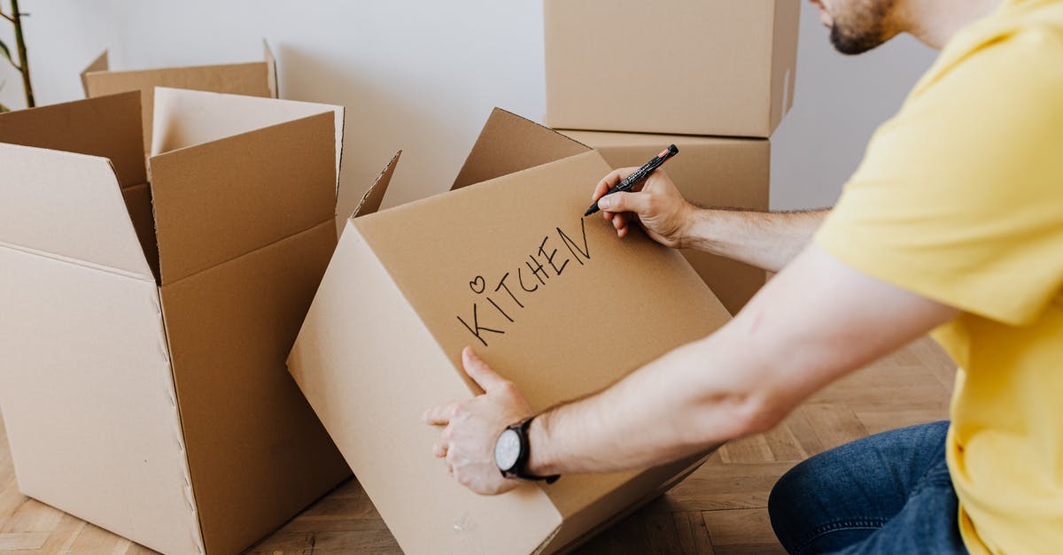 Any Airlines with Open ended tickets where Return can be determined later by design, or without a change fee? - Crop man with pile of cardboard boxes for packing belongings