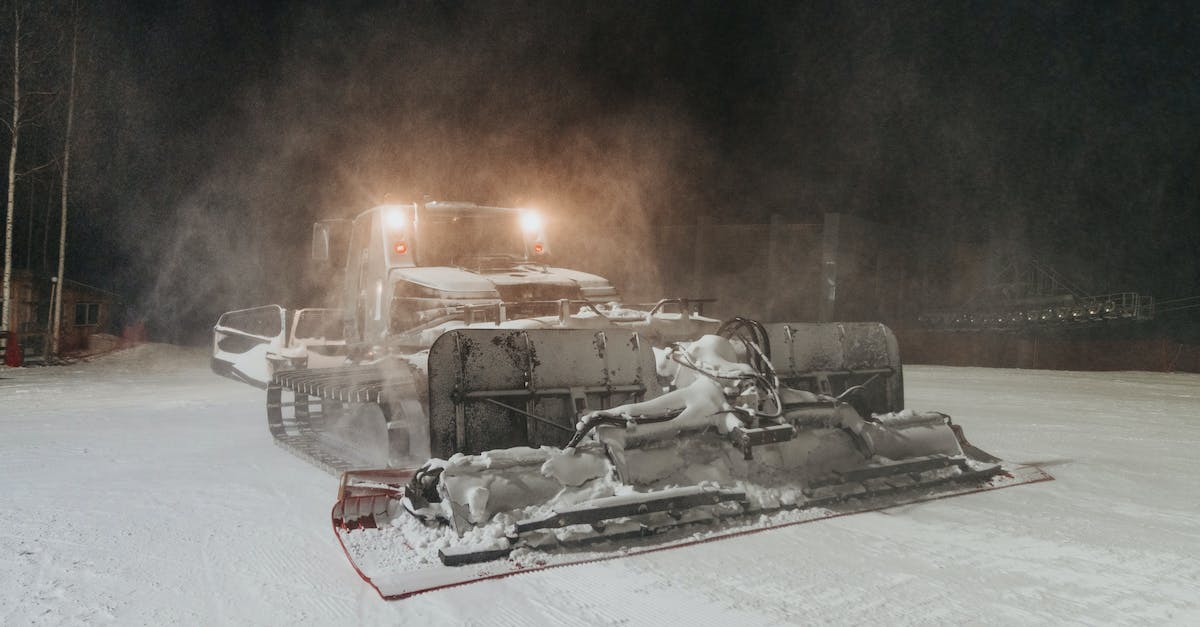 Any special requirements in driving from Spain to France? - Modern massive snowcat with headlights driving and preparing slope for skiing in evening time Any special requirements in driving from Spain to France? - Modern massive snowcat with headlights driving and preparing slope for skiing in evening time