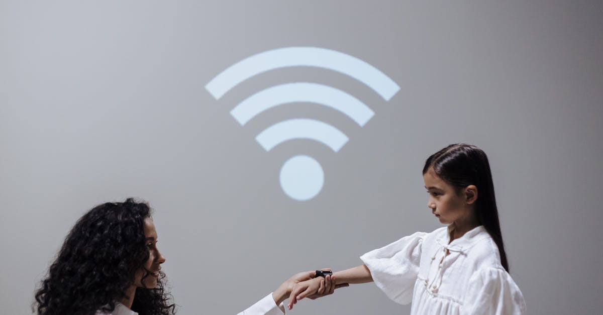 Any tips and tricks to get a better Wi-Fi connection in airports? - Mother and daughter with smartwatch and Wi-Fi symbol Any tips and tricks to get a better Wi-Fi connection in airports? - Mother and daughter with smartwatch and Wi-Fi symbol