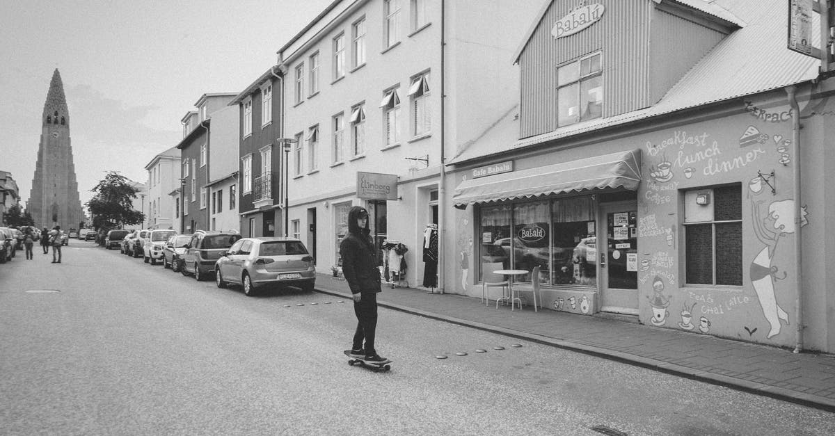 Anything to do in Reykjavik airport at 9 am during a 1h30m layover? - Grayscale Photo of Man Walking on Street Anything to do in Reykjavik airport at 9 am during a 1h30m layover? - Grayscale Photo of Man Walking on Street