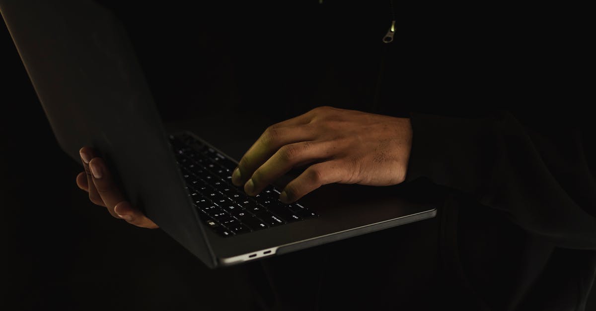 App or website showing cheap business class flights? - Crop unrecognizable man using laptop in darkness App or website showing cheap business class flights? - Crop unrecognizable man using laptop in darkness