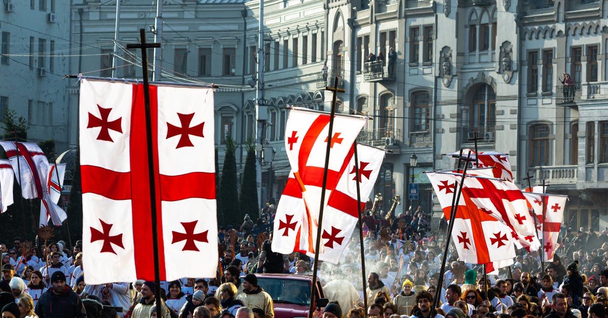 Applying for a Georgia tourism visa - Crowd of people waving flags of Georgia during celebration of religious holiday on Christmas day in Tbilisi Applying for a Georgia tourism visa - Crowd of people waving flags of Georgia during celebration of religious holiday on Christmas day in Tbilisi