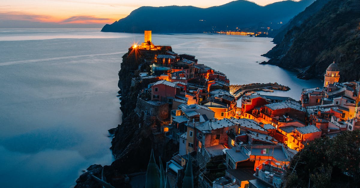 Applying for a UK Settlement Visa from Italy with an expired Permesso di Soggiorno [closed] - Amazing landscape of small village with illuminate ancient tower and colorful buildings located on rocky cliff in front of sea in Italy