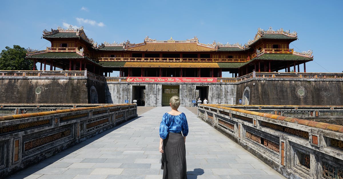 Applying for South Korean tourist visas - Full body back view of anonymous female traveler strolling on paved walkway near South Gate in Imperial City in Hue Applying for South Korean tourist visas - Full body back view of anonymous female traveler strolling on paved walkway near South Gate in Imperial City in Hue