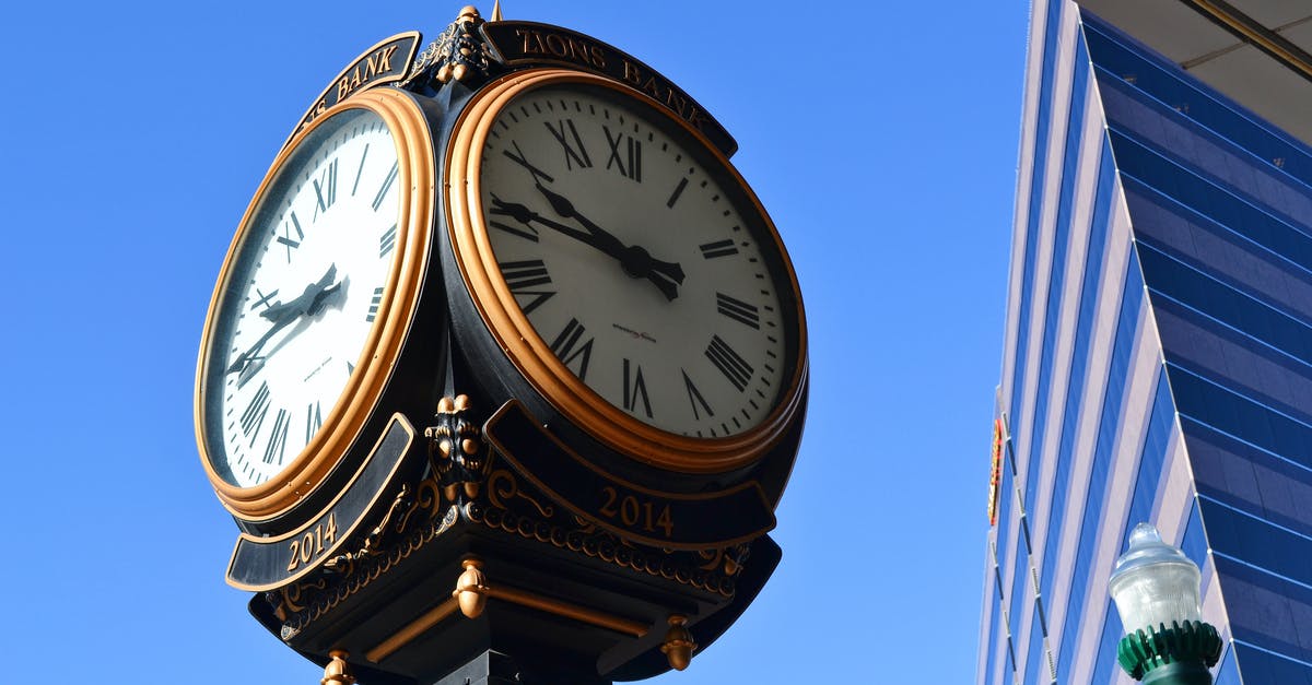 Are 7 hours enough time to leave the Brussels airport and go to the city center? - Close-up Photo of Street Clock Near Tall Building