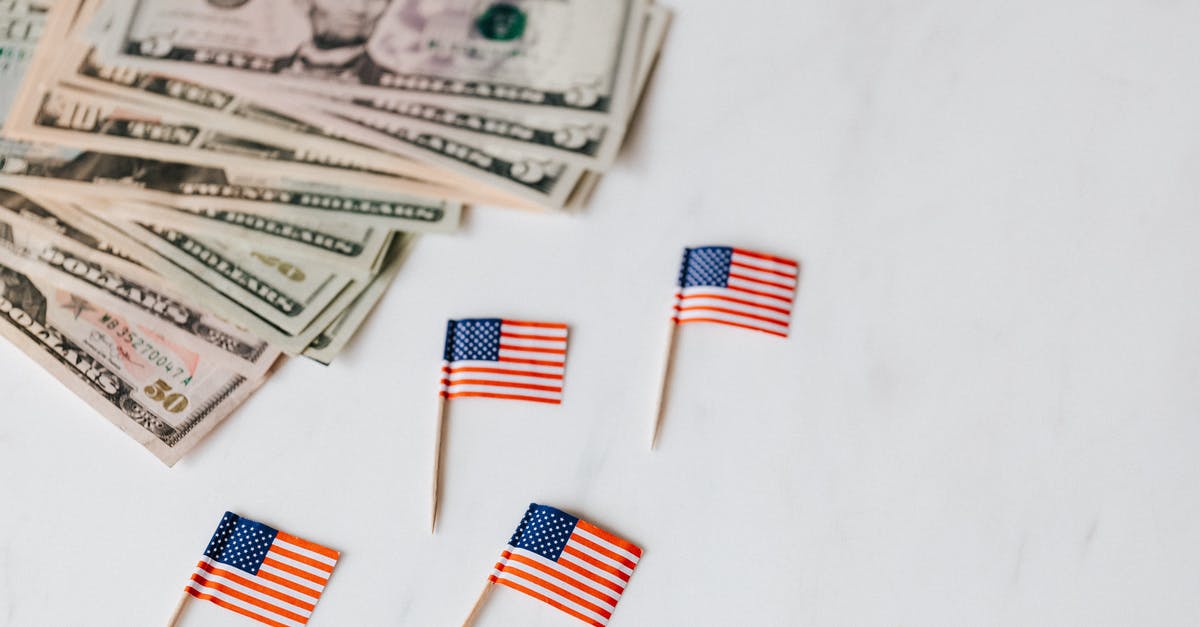 Are back-to-back working holidays in different countries possible? - From above of flags of United States of America on toothpicks placed near bundle of American dollars of different nominal pars on white surface of table Are back-to-back working holidays in different countries possible? - From above of flags of United States of America on toothpicks placed near bundle of American dollars of different nominal pars on white surface of table