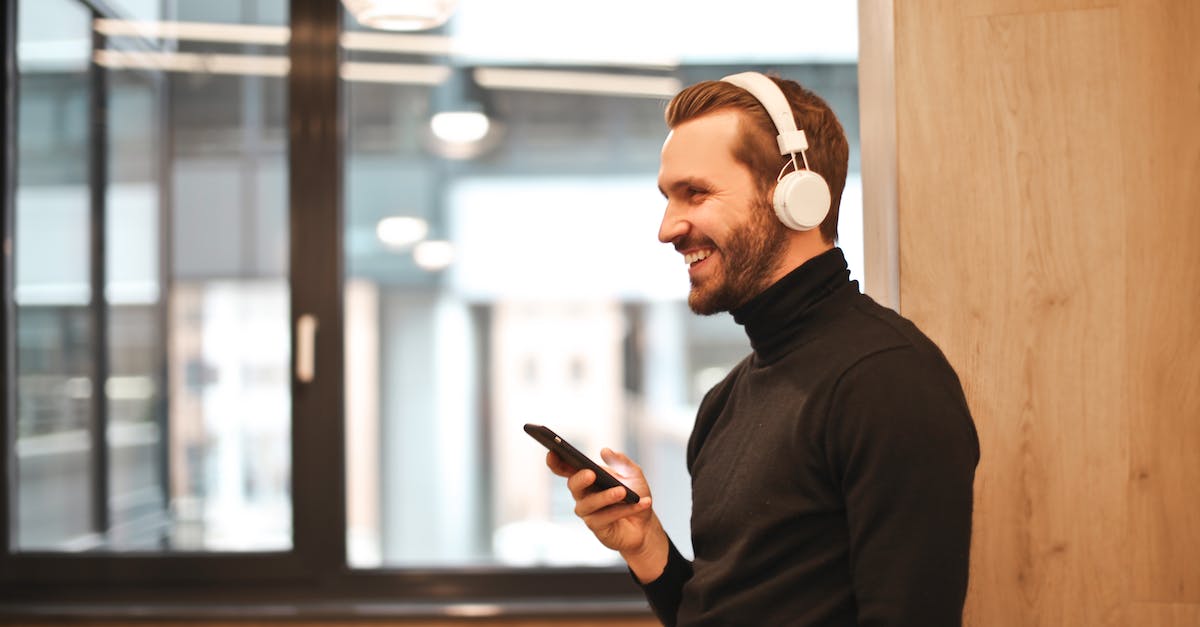 Are bluetooth headphones allowed on flights in the US, particularly on United Airlines? - Man Wearing Black Long Sleeve Shirt While Holding Black Smartphone