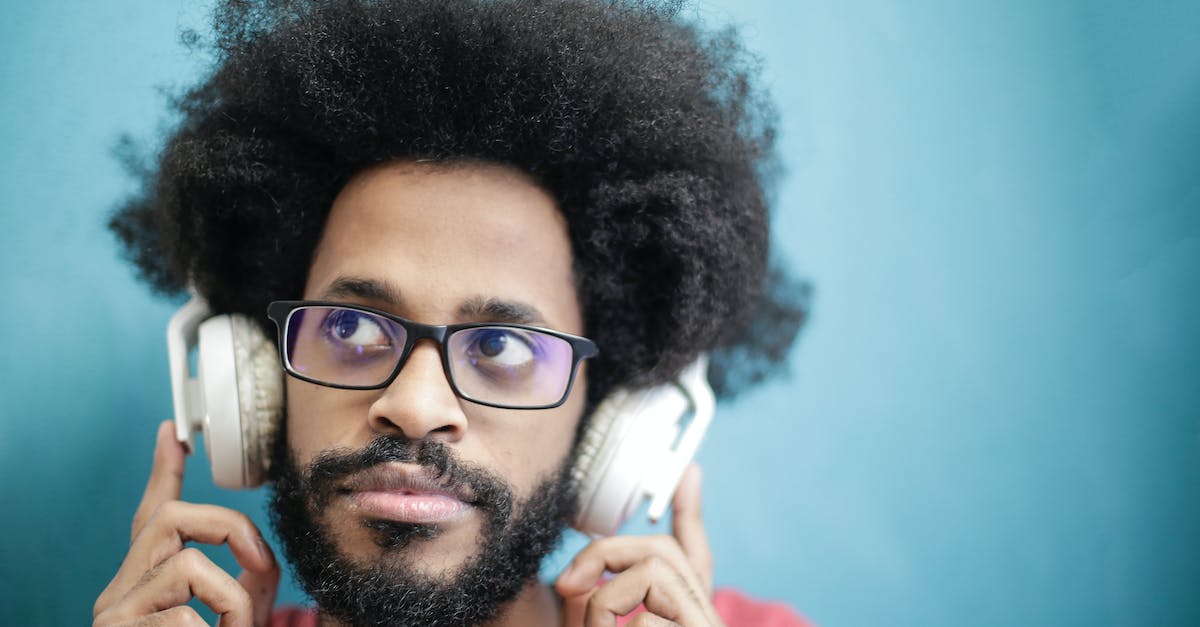 Are bluetooth headphones allowed on flights in the US, particularly on United Airlines? - Man in Black Framed Eyeglasses Wearing Headphones