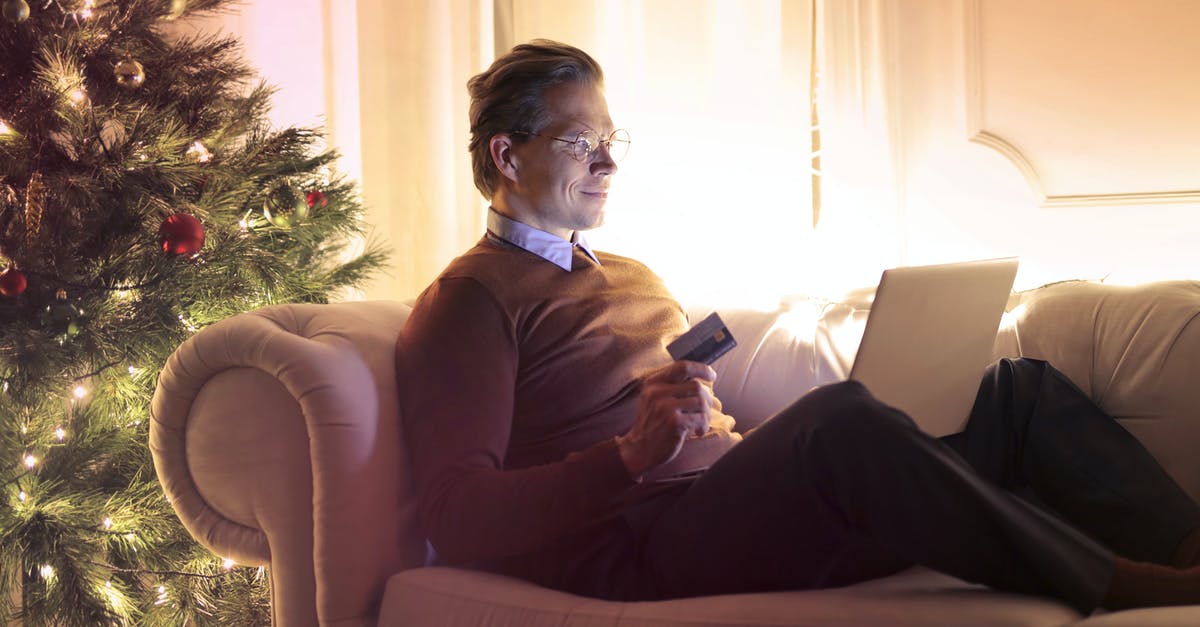 Are credit cards accepted in Strasbourg Christmas markets? - Man in Brown Long Sleeve Sweater and Black Pants Sitting on Brown Sofa Chair Using Laptop Are credit cards accepted in Strasbourg Christmas markets? - Man in Brown Long Sleeve Sweater and Black Pants Sitting on Brown Sofa Chair Using Laptop