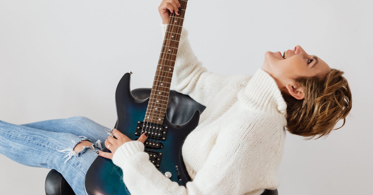 Are electric hair straighteners allowed on flights? - Side view of cheerful short haired female in casual clothes laughing while playing electric guitar in comfortable armchair against white background Are electric hair straighteners allowed on flights? - Side view of cheerful short haired female in casual clothes laughing while playing electric guitar in comfortable armchair against white background