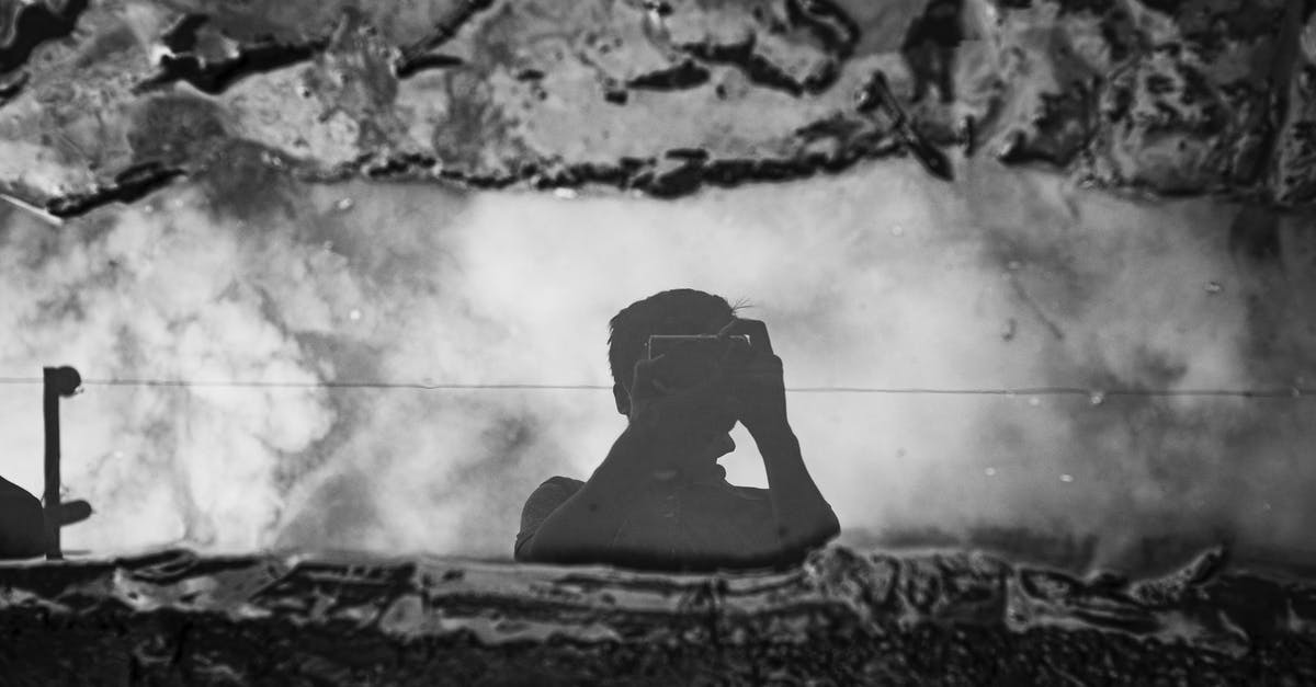 Are French hotels currently prohibited from using air conditioning? - Faceless photographer taking photo of puddle between dirt on camera Are French hotels currently prohibited from using air conditioning? - Faceless photographer taking photo of puddle between dirt on camera