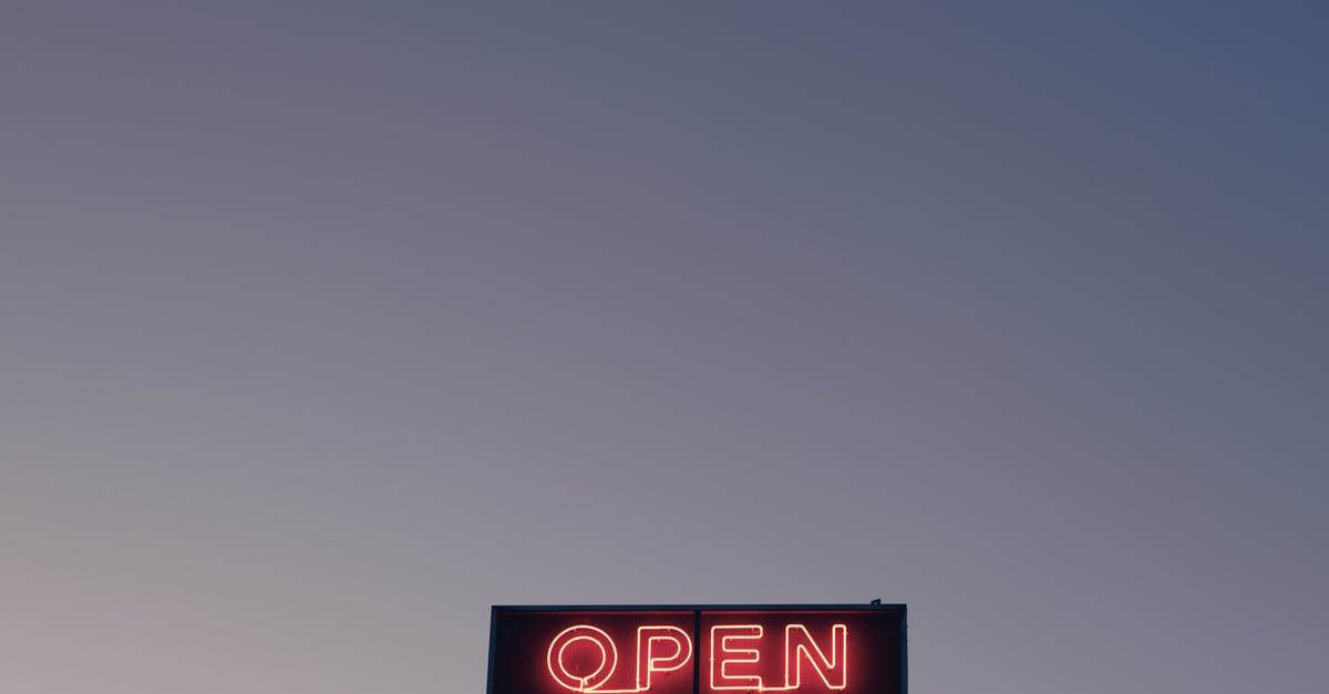 Are hotels open to public? - From below of illuminated signboard with Open red neon inscription against cloudless sunset sky Are hotels open to public? - From below of illuminated signboard with Open red neon inscription against cloudless sunset sky