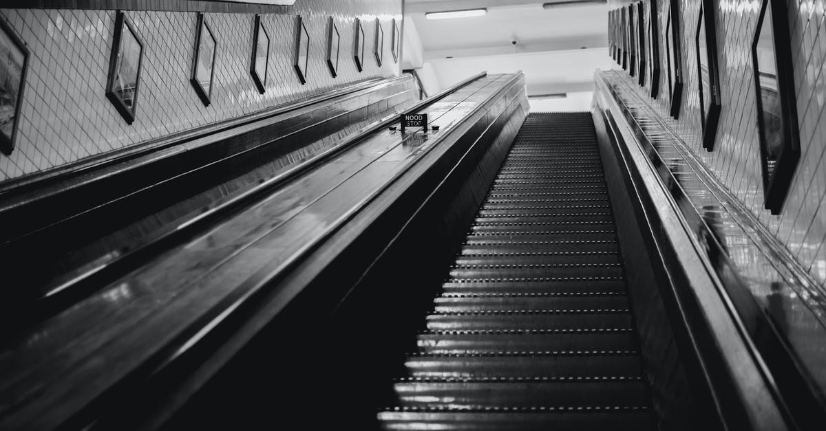 Are Italian residents exempt from needing a UK direct airside transit visa? - Black and white of from below of stairway with railings inside modern building with tiled walls decorated with pictures in black frames Are Italian residents exempt from needing a UK direct airside transit visa? - Black and white of from below of stairway with railings inside modern building with tiled walls decorated with pictures in black frames