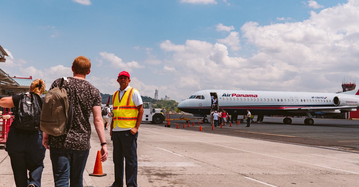 Are most staff at Brussels airport Dutch or French-speaking? - Standing Person Wearing Yellow and Red Vest Are most staff at Brussels airport Dutch or French-speaking? - Standing Person Wearing Yellow and Red Vest