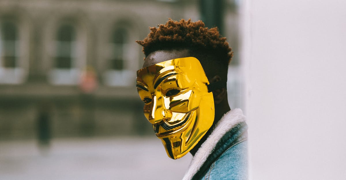 Are state boundaries a problem when using taxis in the USA? - Black activist in golden Anonymous mask standing on city street Are state boundaries a problem when using taxis in the USA? - Black activist in golden Anonymous mask standing on city street