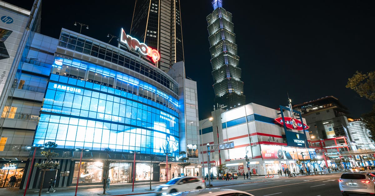 Are Taiwan car rental prices really that high? - City with illuminated buildings and skyscrapers near road with cars Are Taiwan car rental prices really that high? - City with illuminated buildings and skyscrapers near road with cars